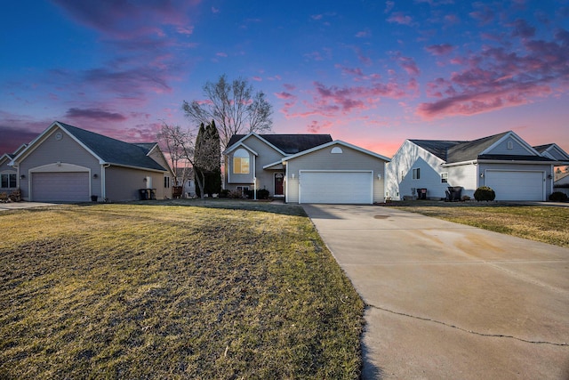 ranch-style home featuring a front yard, concrete driveway, and an attached garage