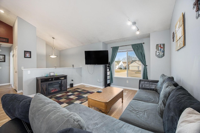 living room with baseboards, lofted ceiling, and wood finished floors