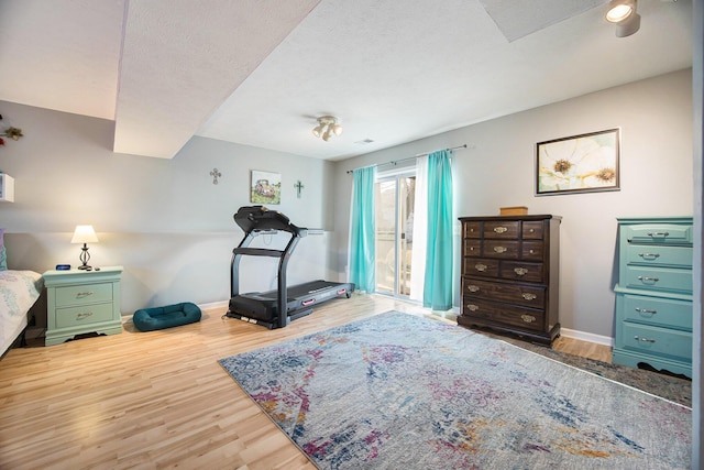 workout area featuring baseboards and wood finished floors