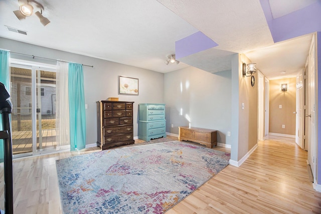 bedroom featuring access to exterior, visible vents, baseboards, and wood finished floors