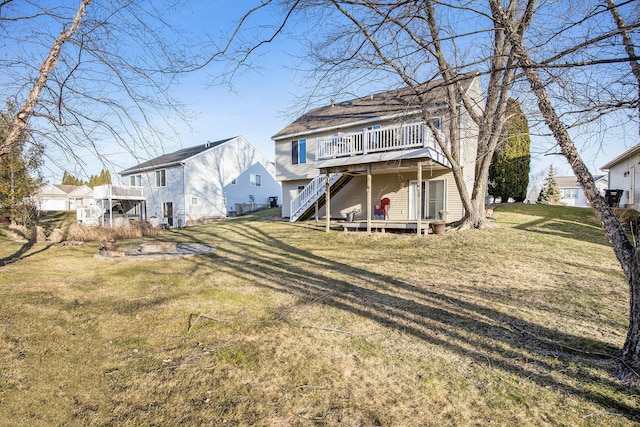 rear view of property featuring a lawn, stairs, and a deck