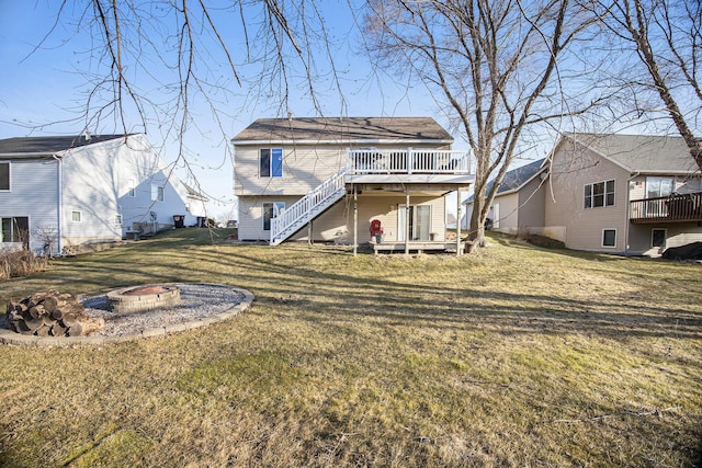 rear view of property featuring a wooden deck, stairway, a yard, and an outdoor fire pit