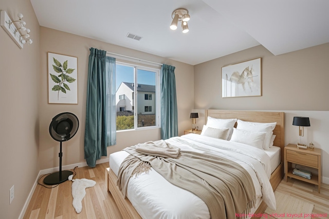 bedroom featuring visible vents, baseboards, and wood finished floors