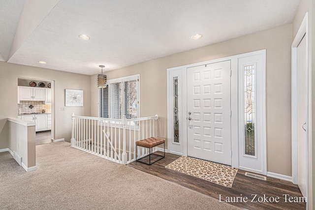 entryway with wood finished floors, recessed lighting, baseboards, and visible vents