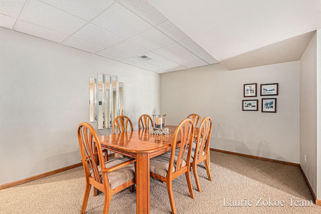 dining area with light colored carpet, visible vents, a drop ceiling, and baseboards