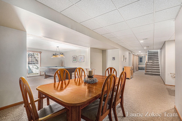 dining area with light carpet, billiards, a drop ceiling, stairway, and baseboards