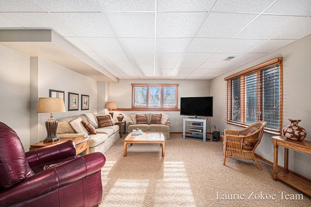 living room featuring carpet flooring, baseboards, a paneled ceiling, and visible vents