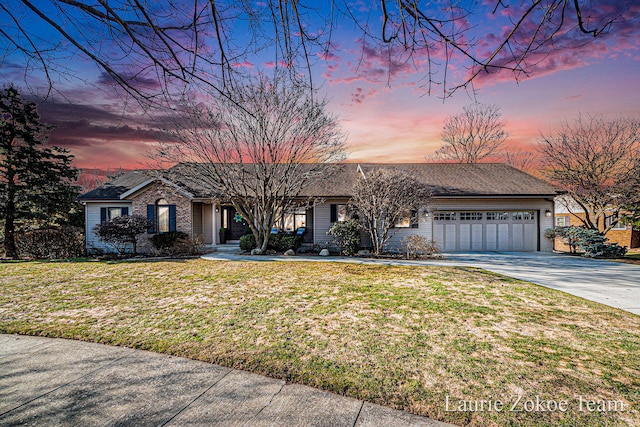 view of front facade featuring a garage, concrete driveway, and a front yard