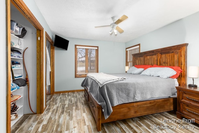 bedroom featuring ceiling fan, baseboards, and light wood-style floors