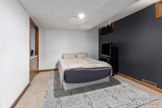 bedroom featuring light carpet, visible vents, a paneled ceiling, and baseboards