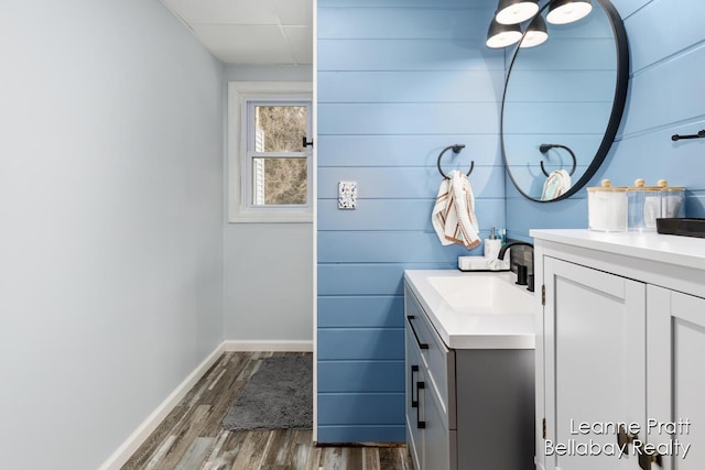 bathroom featuring vanity, wood finished floors, and baseboards