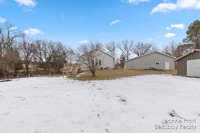 yard layered in snow featuring an outbuilding