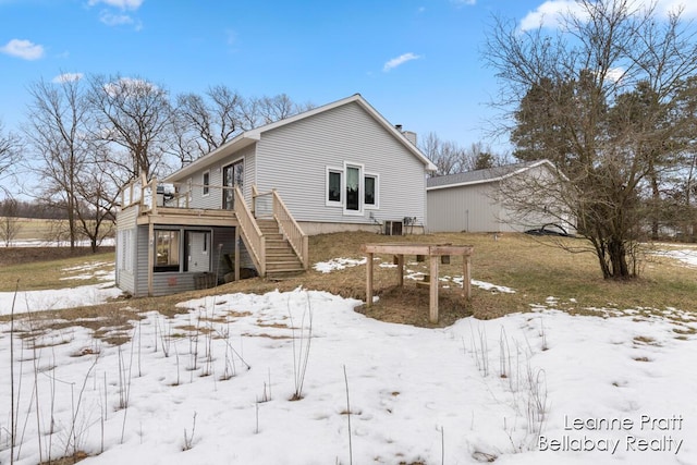 snow covered property featuring a wooden deck and stairs