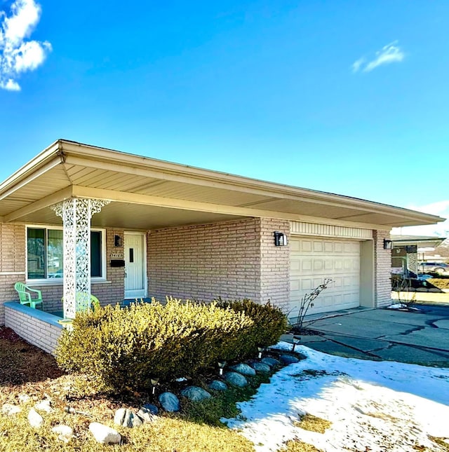 ranch-style house featuring brick siding, concrete driveway, and a garage