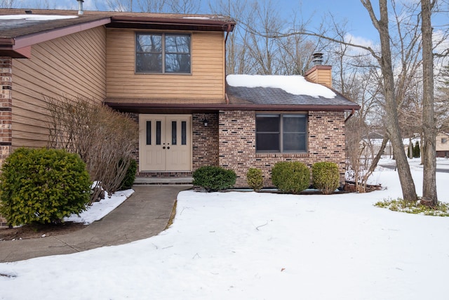 exterior space with brick siding and a chimney