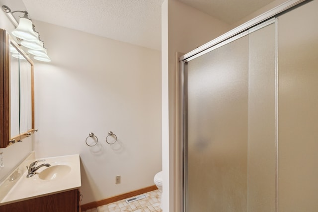 bathroom with vanity, visible vents, a shower stall, a textured ceiling, and toilet