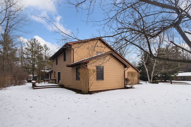 view of snowy exterior with a wooden deck