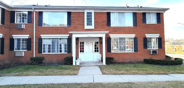 view of front of property featuring brick siding and a front lawn