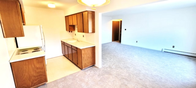 kitchen with a sink, light colored carpet, light countertops, brown cabinetry, and a baseboard radiator