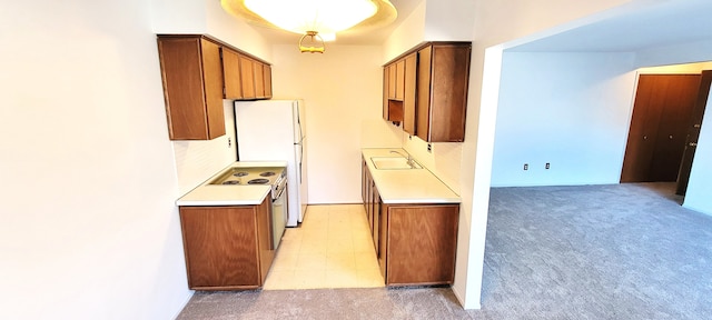 kitchen with light carpet, brown cabinets, light countertops, and electric range oven