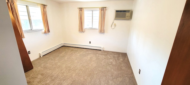 carpeted empty room with a baseboard heating unit, a wall unit AC, and a wealth of natural light