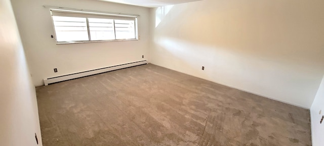 carpeted spare room featuring a baseboard heating unit