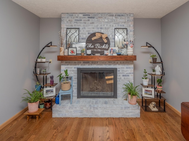 interior details with a fireplace, wood finished floors, and a textured ceiling