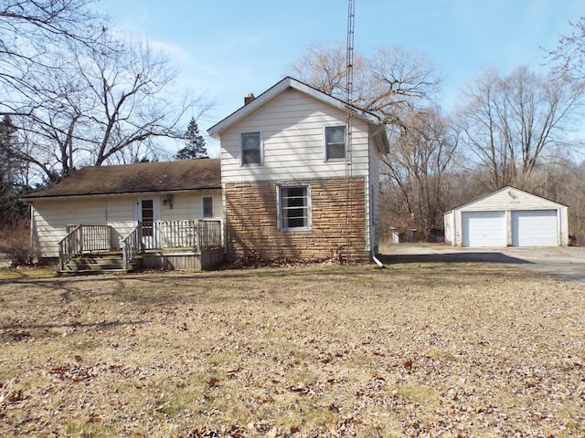 back of property featuring a chimney, a deck, a garage, an outdoor structure, and stone siding