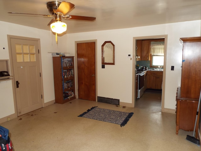 foyer with baseboards and a ceiling fan