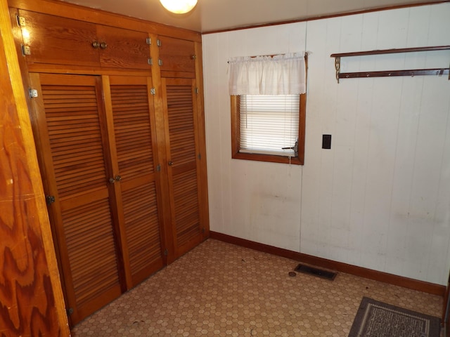 unfurnished bedroom with tile patterned floors, baseboards, visible vents, and a closet