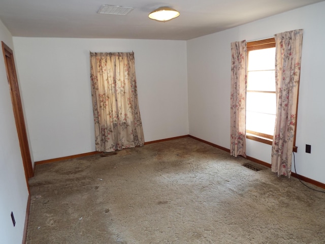 carpeted spare room featuring visible vents and baseboards