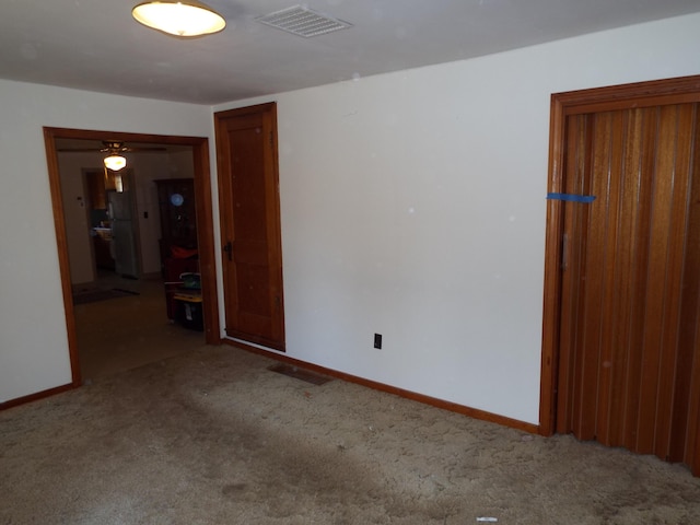 unfurnished room with visible vents, baseboards, and carpet flooring