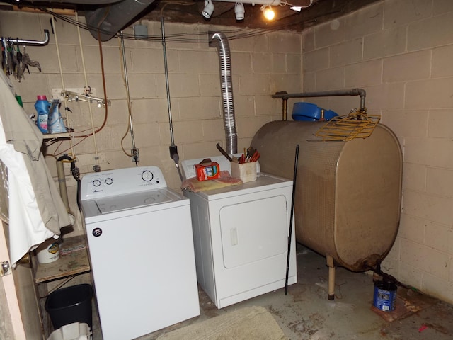 clothes washing area featuring laundry area, heating fuel, and washing machine and clothes dryer