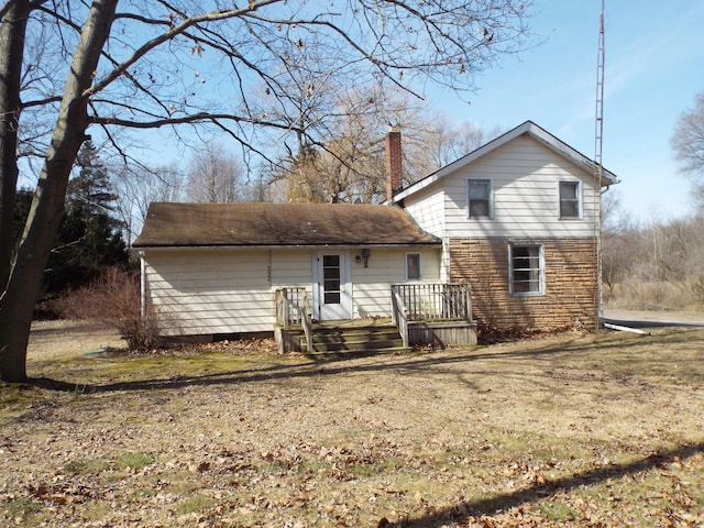 back of property featuring a deck and a chimney