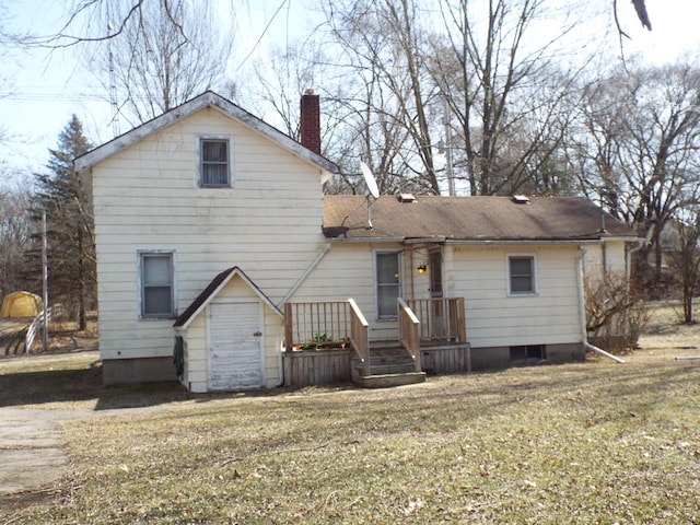 back of property with a lawn and a chimney