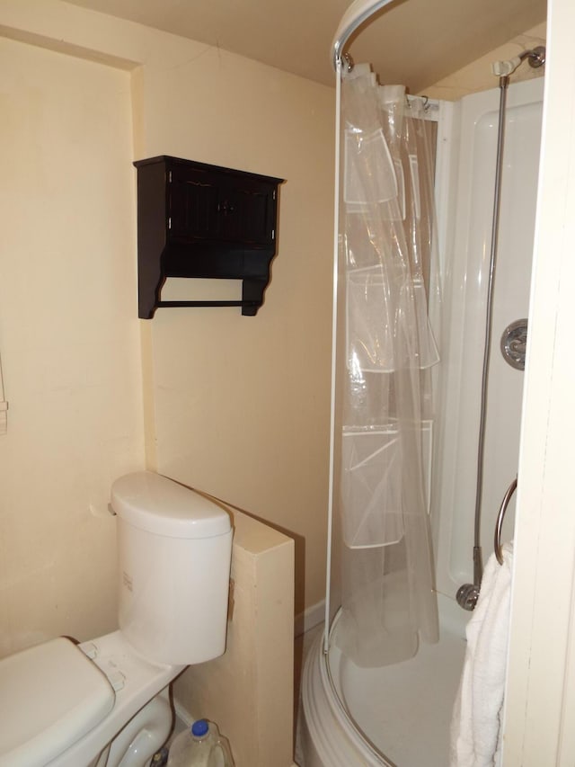 full bath featuring a shower stall and toilet