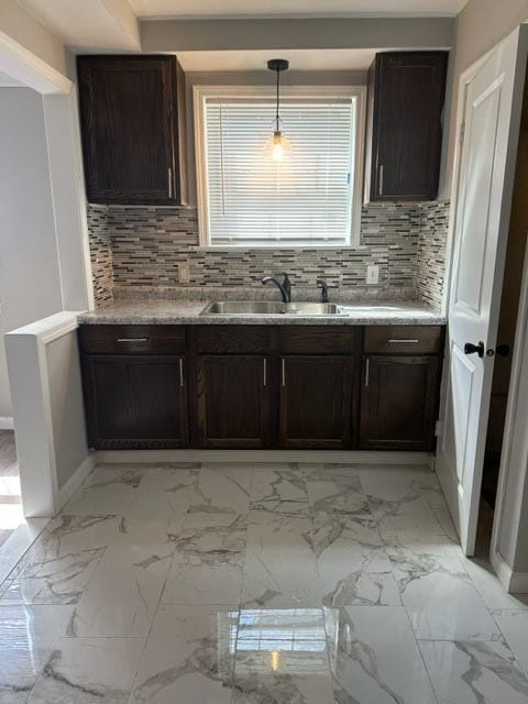 18635 Dale St, Detroit, MI 48219 - kitchen featuring marble finish floor, backsplash, dark brown cabinetry, and a sink