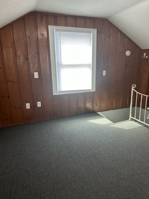 18635 Dale St, Detroit, MI 48219 - additional living space with carpet flooring, wooden walls, and vaulted ceiling