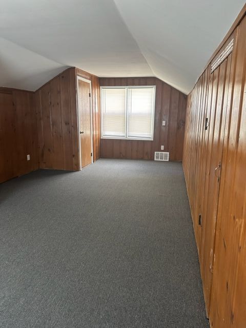 18635 Dale St, Detroit, MI 48219 - bonus room with carpet flooring, wooden walls, vaulted ceiling, and visible vents