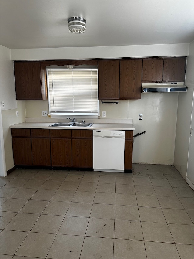 kitchen featuring under cabinet range hood, a sink, dark brown cabinetry, white dishwasher, and light countertops