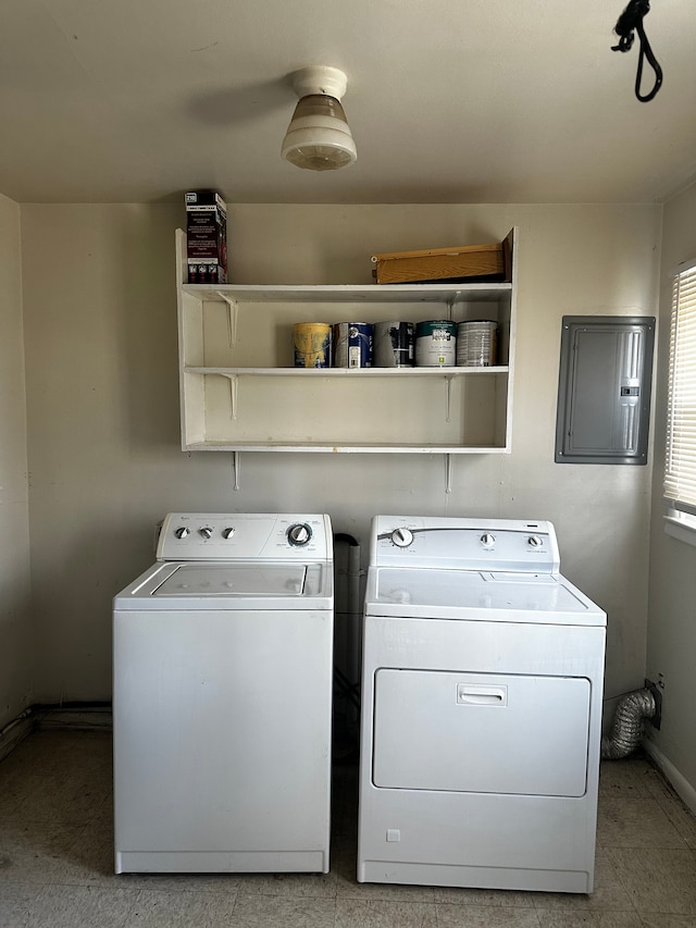 laundry area with electric panel, baseboards, separate washer and dryer, and laundry area