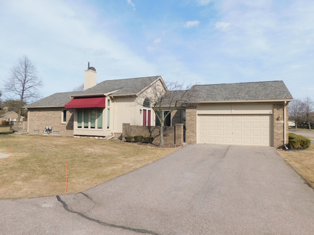 view of front of house featuring brick siding, a front lawn, aphalt driveway, roof with shingles, and a garage