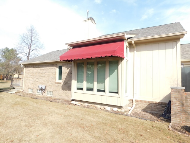 rear view of house featuring a shingled roof