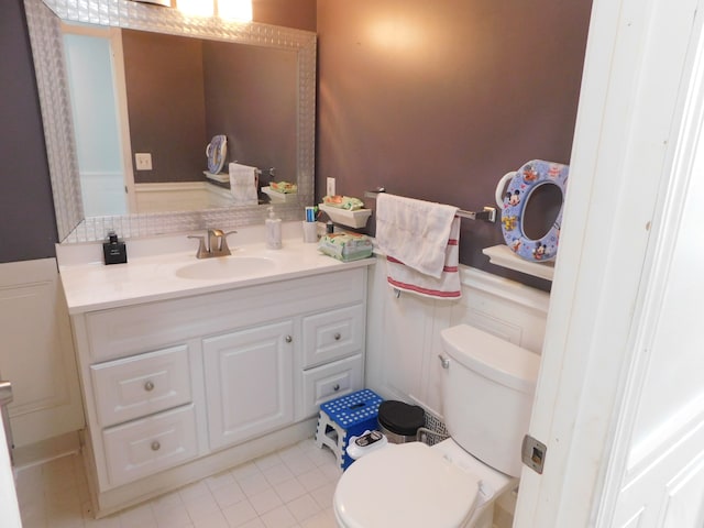 bathroom with toilet, vanity, and tile patterned flooring