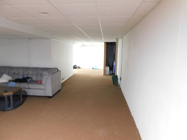 corridor featuring a paneled ceiling and carpet floors