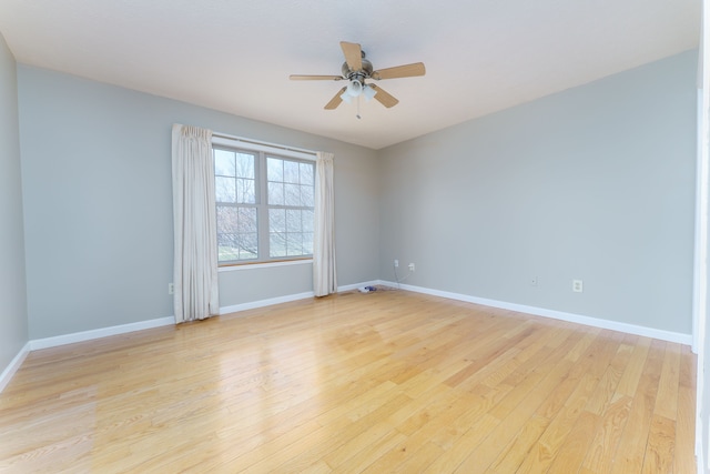 empty room with baseboards, light wood-style floors, and a ceiling fan