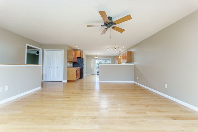 unfurnished living room with baseboards, light wood-style flooring, and a ceiling fan