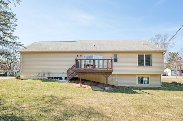 rear view of house with a lawn, a deck, and a shingled roof