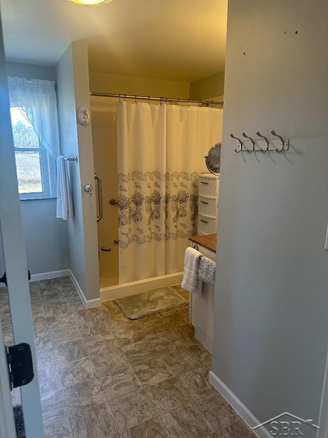 full bath with a shower with shower curtain and baseboards