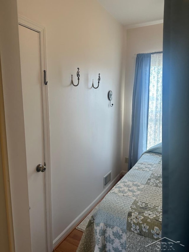 bedroom featuring visible vents, baseboards, and wood finished floors